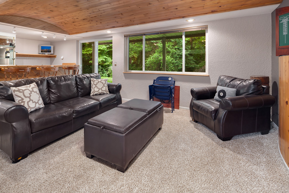 Example of a large transitional walk-out carpeted and beige floor basement design in Omaha with gray walls, a standard fireplace and a wood fireplace surround