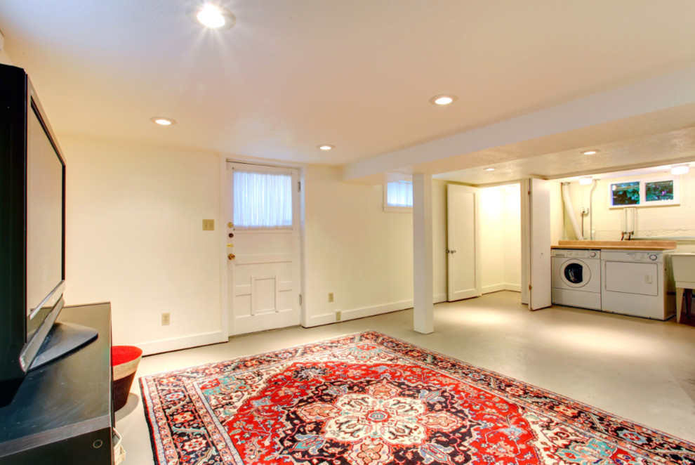 Imagen de sótano con puerta clásico de tamaño medio con paredes beige, suelo de cemento y suelo gris