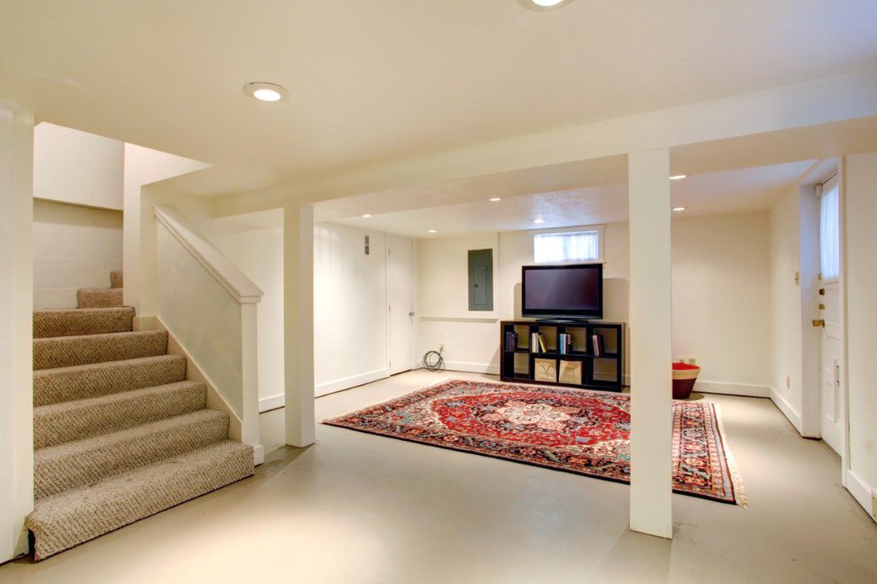 Example of a mid-sized classic walk-out concrete floor and gray floor basement design in Providence with beige walls