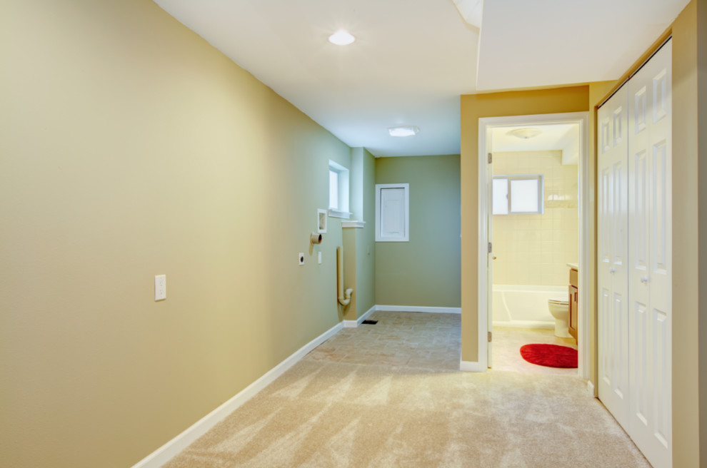 Idée de décoration pour un petit sous-sol tradition avec un mur beige, moquette et un sol beige.