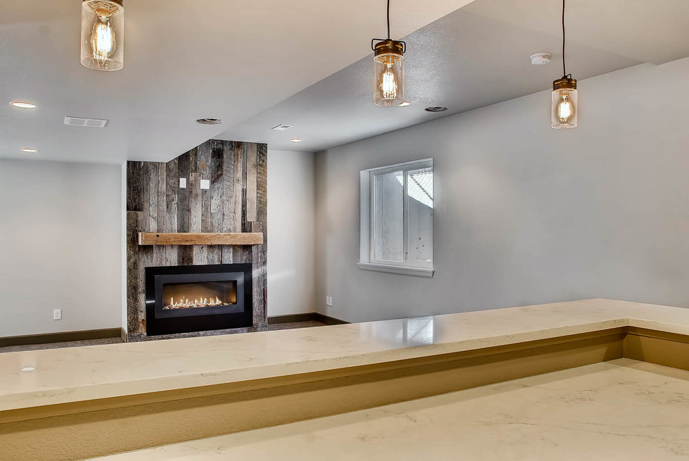Inspiration for a mid-sized industrial underground carpeted and gray floor basement remodel in Denver with white walls, a standard fireplace and a wood fireplace surround