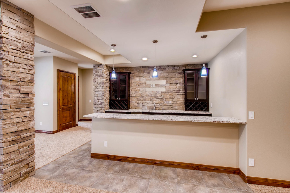 Geräumiges Modernes Untergeschoss mit beiger Wandfarbe, Teppichboden, Kamin, Kaminumrandung aus Stein und beigem Boden in Denver