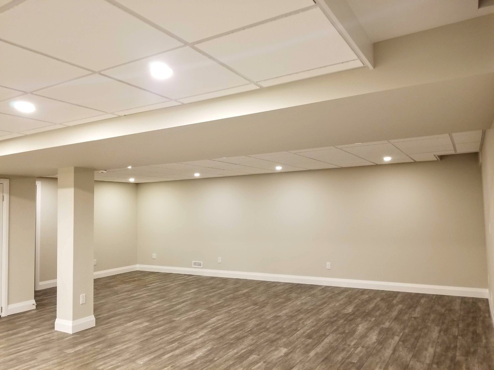 Large elegant look-out vinyl floor and brown floor basement photo in Toronto with a bar and beige walls