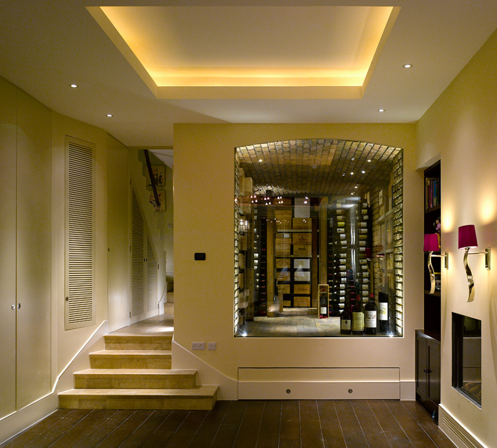 Basement - mid-sized eclectic underground dark wood floor, brown floor and coffered ceiling basement idea in London with yellow walls and a standard fireplace