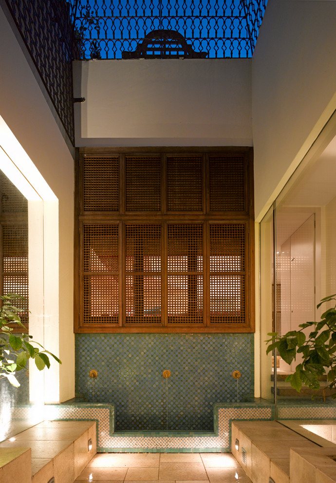 Bild på en mellanstor eklektisk källare utan fönster, med gula väggar, kalkstensgolv och beiget golv
