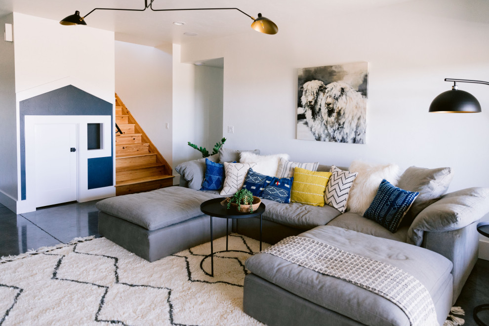 Großes Rustikales Wohnzimmer mit weißer Wandfarbe, Betonboden, Kamin, gefliester Kaminumrandung und grauem Boden in Boise