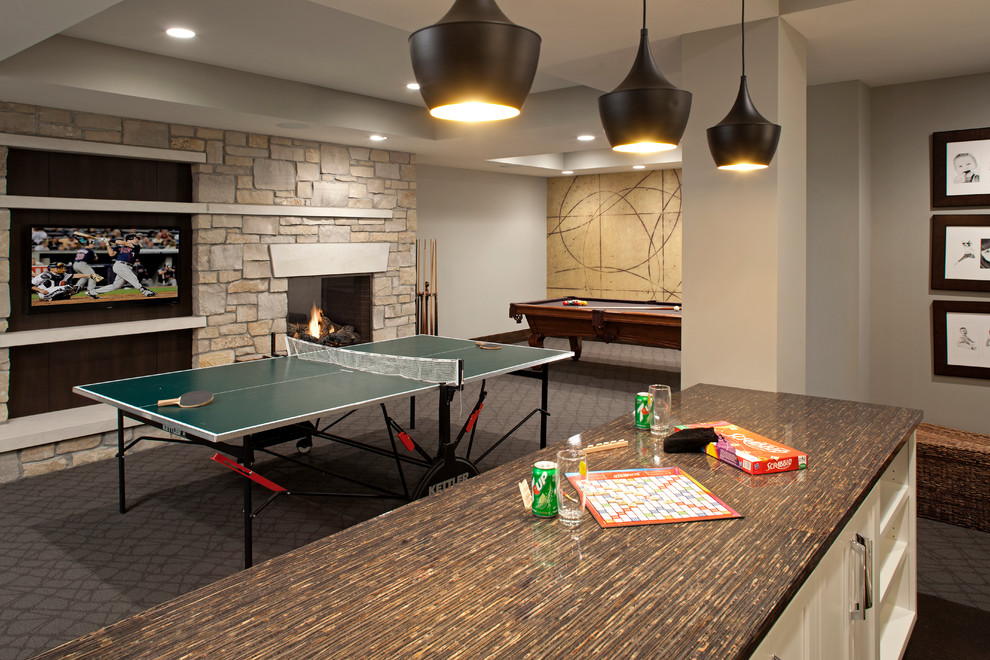 This is an example of a classic basement in Minneapolis with grey walls, carpet, a standard fireplace, a stone fireplace surround, grey floors and a chimney breast.