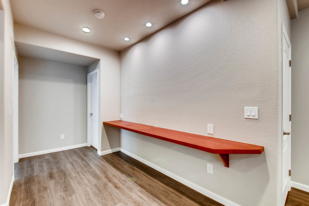 Photo of a large contemporary fully buried basement in Denver with beige walls, carpet, no fireplace and beige floors.
