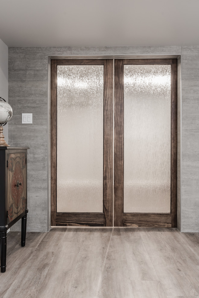Großer Klassischer Hochkeller mit grauer Wandfarbe, Vinylboden, Hängekamin, Kaminumrandung aus Beton und braunem Boden in Toronto