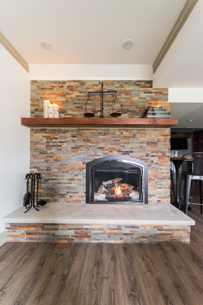 Large mountain style walk-out laminate floor and brown floor basement photo in Philadelphia with white walls, a corner fireplace and a stone fireplace