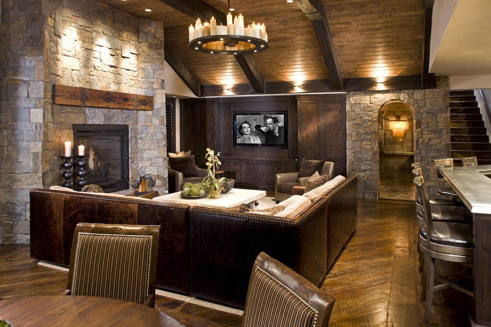 Example of a mountain style underground dark wood floor basement design in Minneapolis with a stone fireplace and a standard fireplace