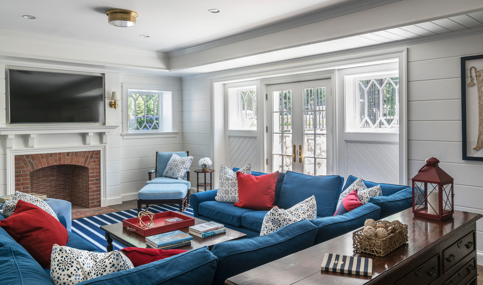 Inspiration for an expansive nautical living room in New York with white walls, a standard fireplace, a brick fireplace surround, a wall mounted tv, dark hardwood flooring and brown floors.