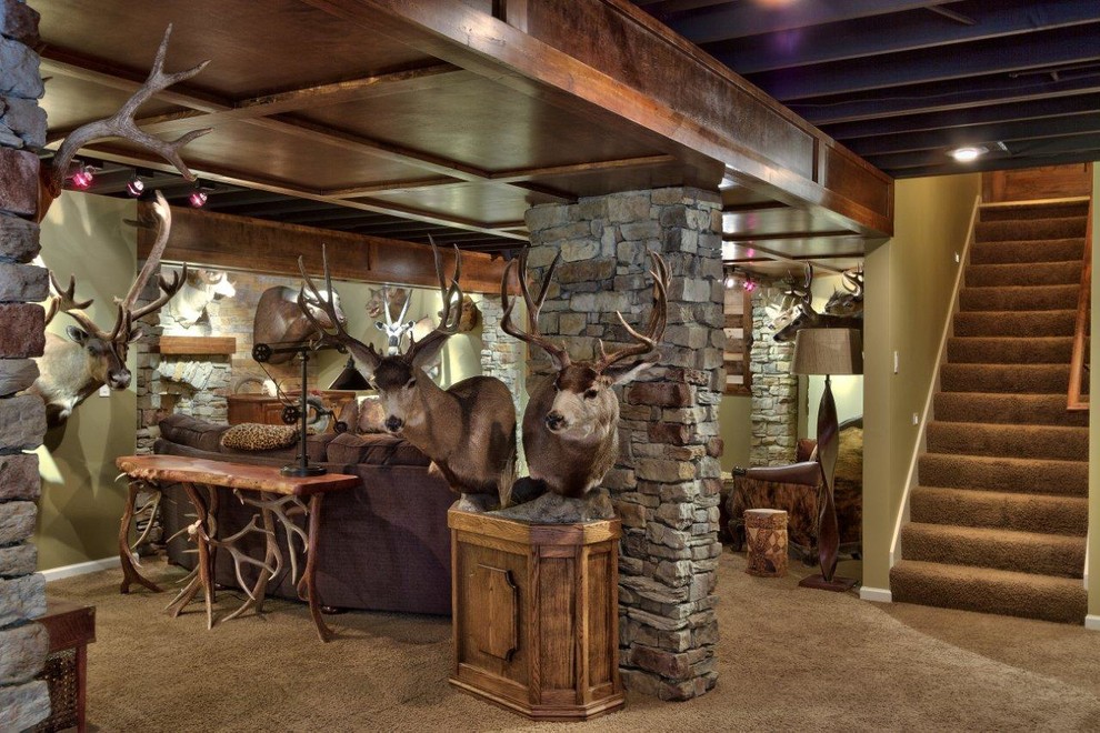 Photo of a large rustic walk-out basement in Kansas City with beige walls, carpet, a standard fireplace and a stone fireplace surround.