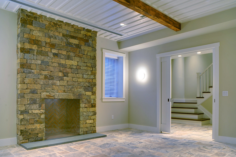 Design ideas for a large classic look-out basement in Manchester with beige walls, travertine flooring, a standard fireplace and a stone fireplace surround.