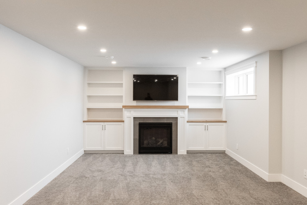 Basement - mid-sized country look-out carpeted and gray floor basement idea in Other with white walls and a standard fireplace