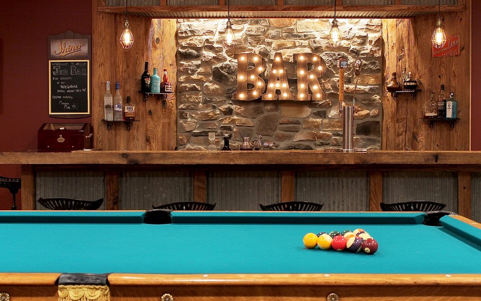 This is an example of a medium sized rustic games room in Philadelphia with brown walls, concrete flooring and beige floors.