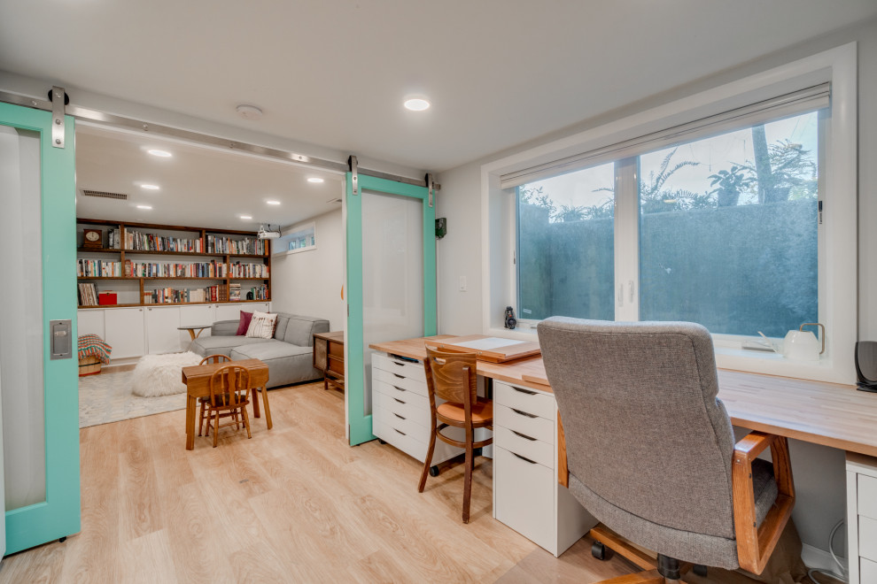 Modernes Arbeitszimmer mit grauer Wandfarbe, hellem Holzboden und beigem Boden in Portland