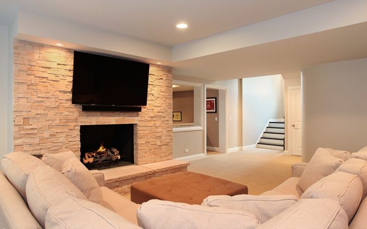 Design ideas for a large traditional fully buried basement in Chicago with beige walls, carpet, a standard fireplace and a stone fireplace surround.