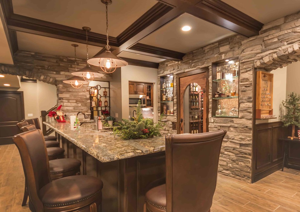 Large mountain style underground ceramic tile and gray floor basement photo in Detroit with beige walls, a standard fireplace and a stone fireplace