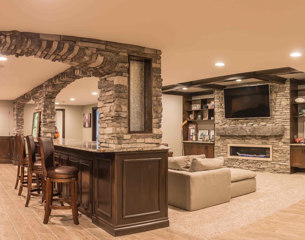 Large rustic fully buried basement in Detroit with beige walls, ceramic flooring, a standard fireplace, a stone fireplace surround and grey floors.