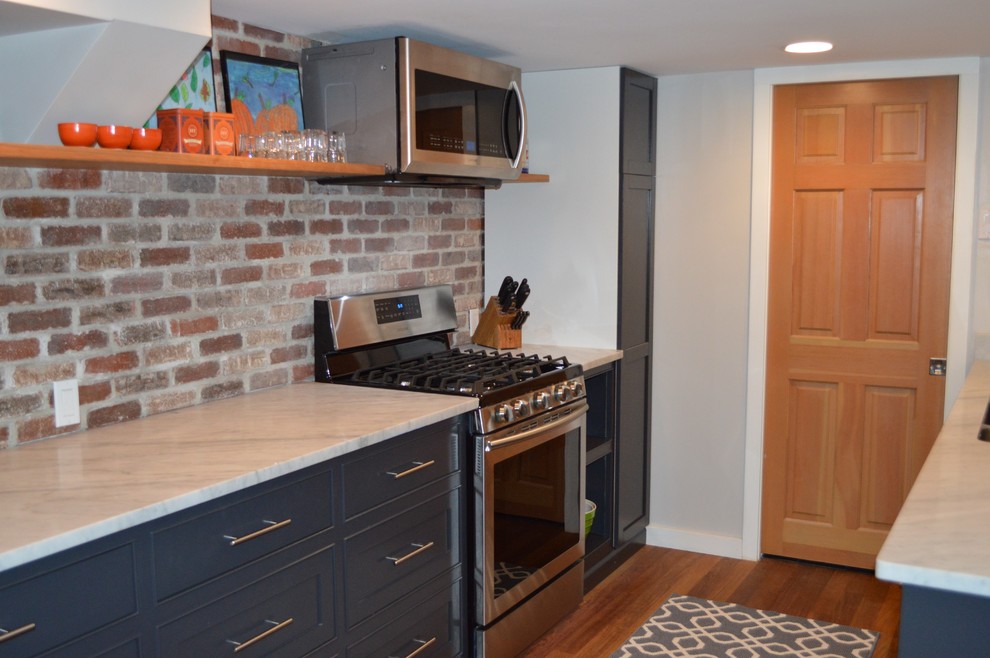 Exemple d'une cuisine parallèle chic de taille moyenne avec un évier 2 bacs, des portes de placard grises, plan de travail en marbre et un électroménager en acier inoxydable.