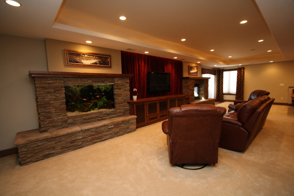 This is an example of a medium sized traditional walk-out basement in Minneapolis with beige walls, carpet and a stone fireplace surround.