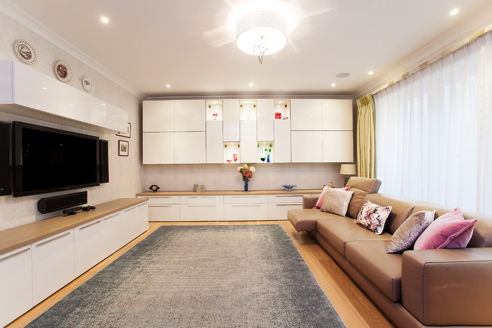 Großes Modernes Untergeschoss ohne Kamin mit weißer Wandfarbe und braunem Holzboden in London