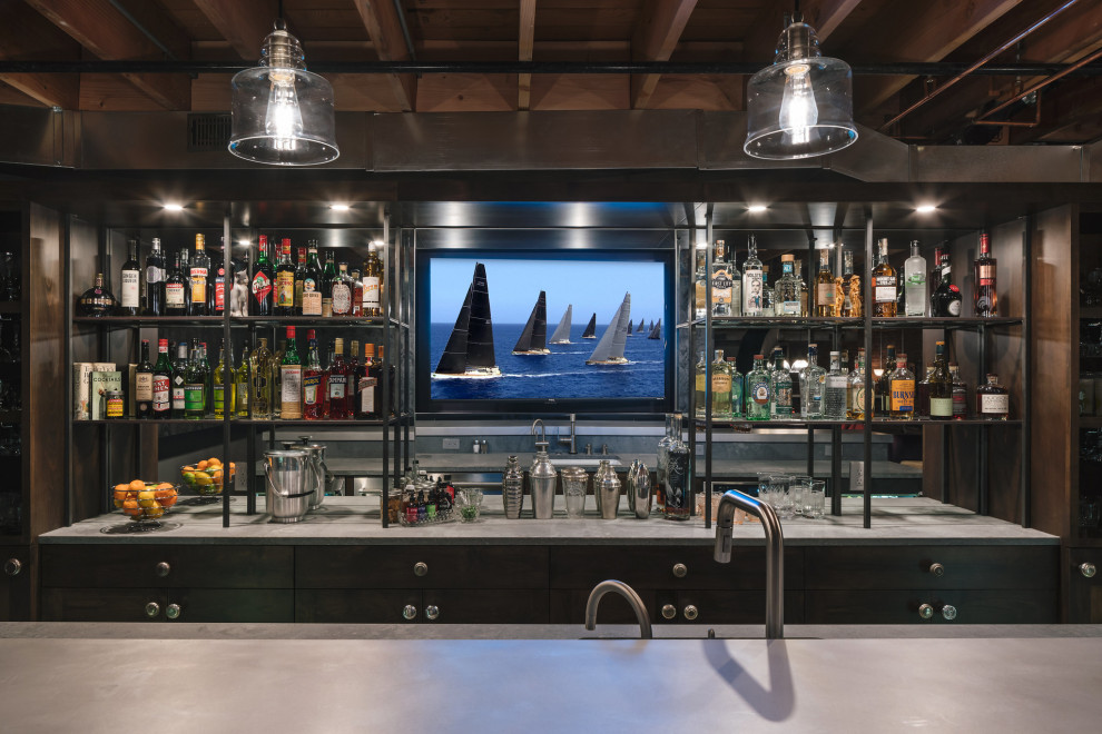 Photo of a large industrial walk-out basement in Portland with a home bar, multi-coloured walls, concrete flooring, a standard fireplace, a brick fireplace surround, grey floors, exposed beams and brick walls.