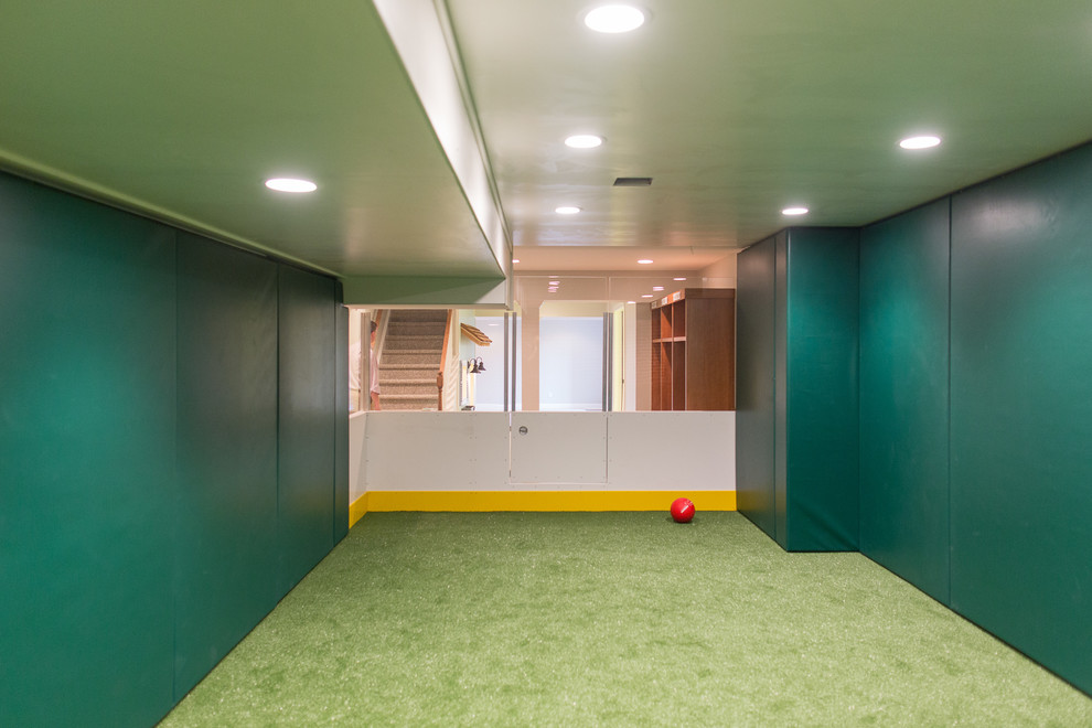 Bild på en stor funkis källare utan fönster, med gröna väggar, heltäckningsmatta och grönt golv