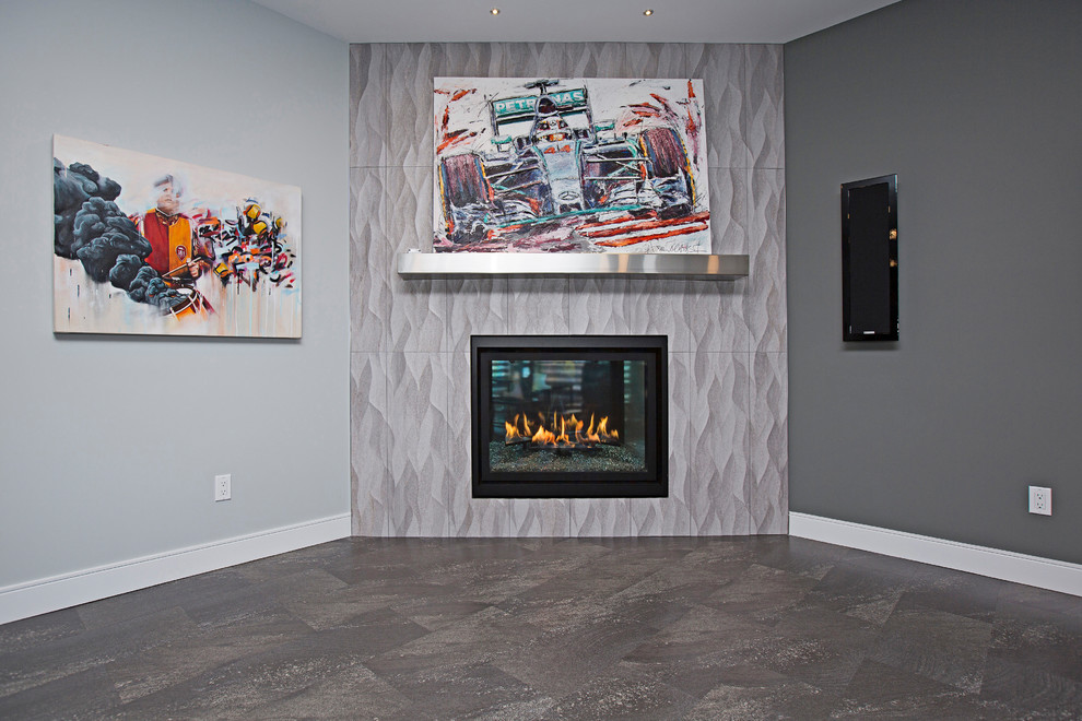 Cette image montre un sous-sol minimaliste donnant sur l'extérieur et de taille moyenne avec un mur gris, un sol en vinyl, une cheminée d'angle, un manteau de cheminée en carrelage et un sol gris.
