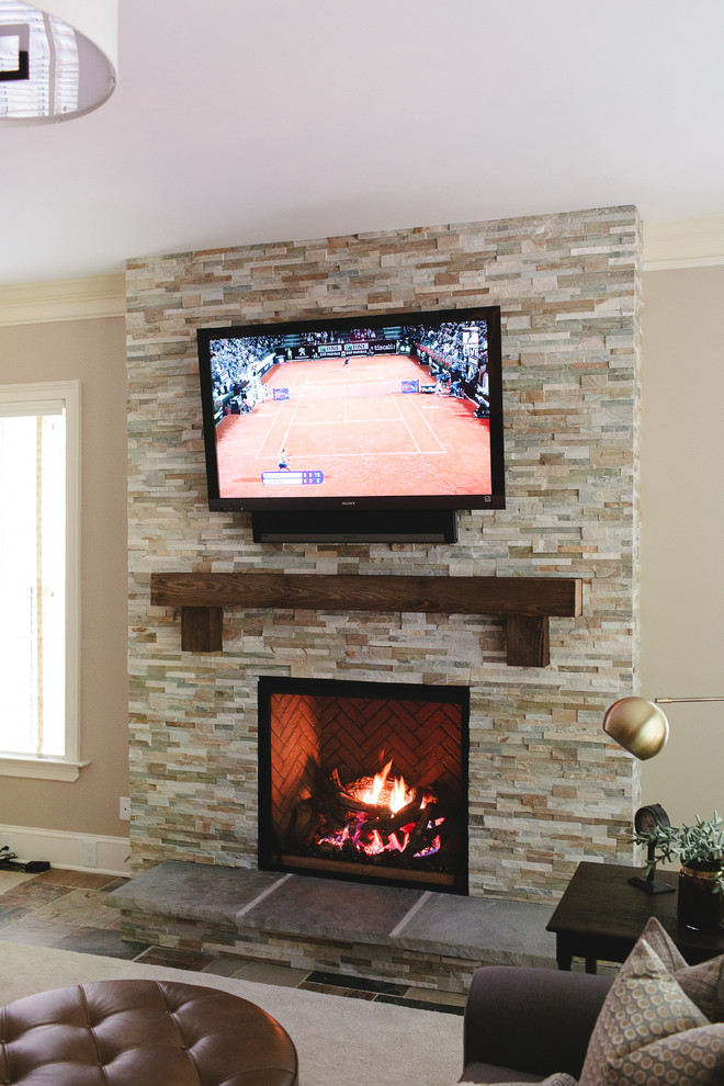 Inspiration for a classic walk-out basement in Atlanta with beige walls, a standard fireplace and a stone fireplace surround.