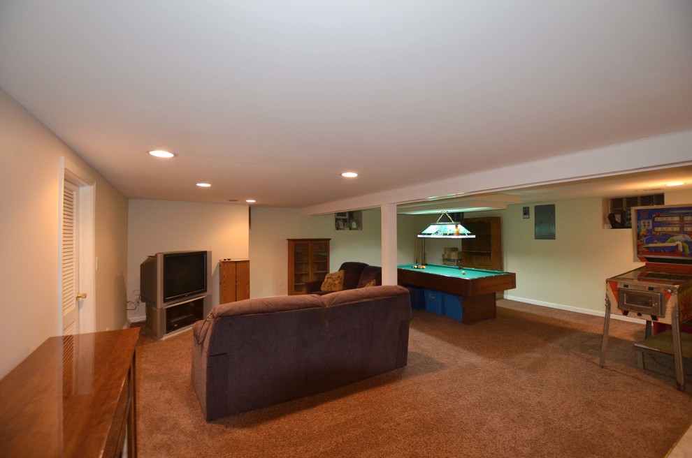 Example of a large classic underground carpeted basement design in Detroit with white walls