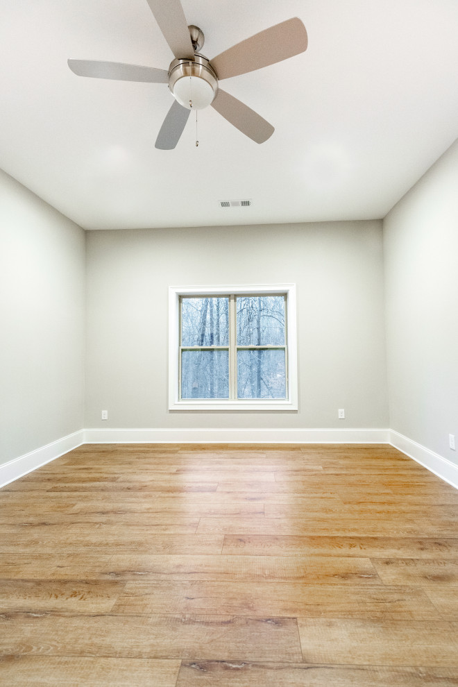Farmhouse light wood floor and brown floor basement photo in Atlanta with gray walls