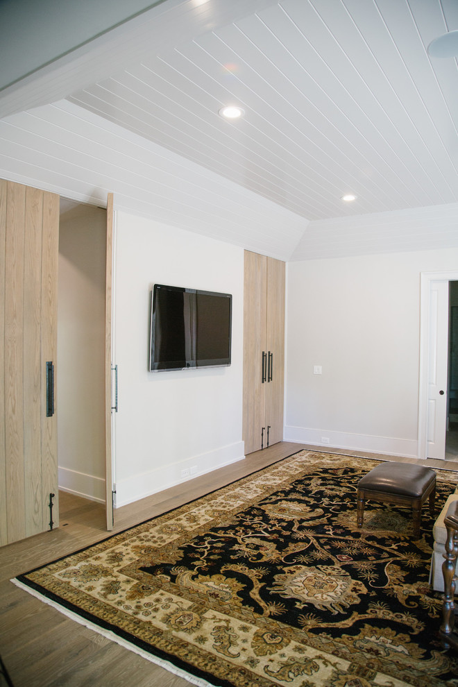Ejemplo de sótano con puerta clásico renovado grande con paredes blancas, suelo de madera clara, todas las chimeneas, marco de chimenea de hormigón y suelo marrón