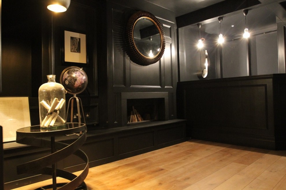Imagen de sótano en el subsuelo clásico grande con paredes negras, suelo de madera en tonos medios y suelo beige