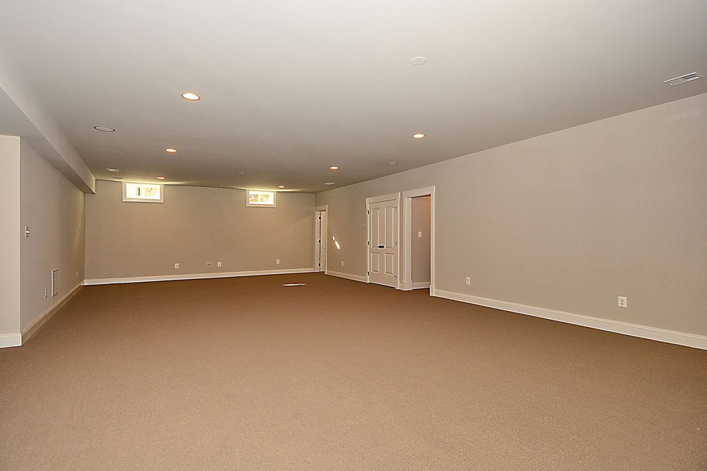 Example of a mid-sized arts and crafts walk-out carpeted basement design in DC Metro with beige walls