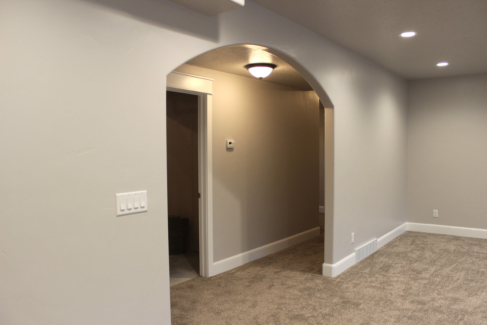 Basement - large traditional underground carpeted basement idea in Salt Lake City with gray walls