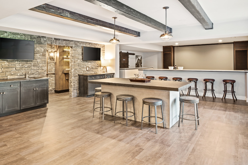 Inspiration for a large country walk-out basement in Cincinnati with white walls, vinyl flooring, a standard fireplace, a stone fireplace surround and brown floors.