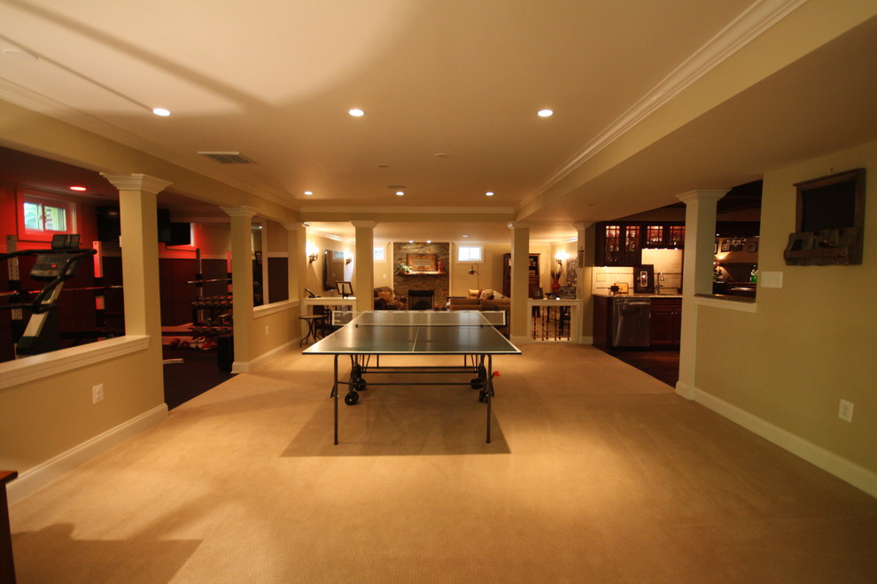 Large mountain style walk-out carpeted basement photo in DC Metro with beige walls, a standard fireplace and a stone fireplace