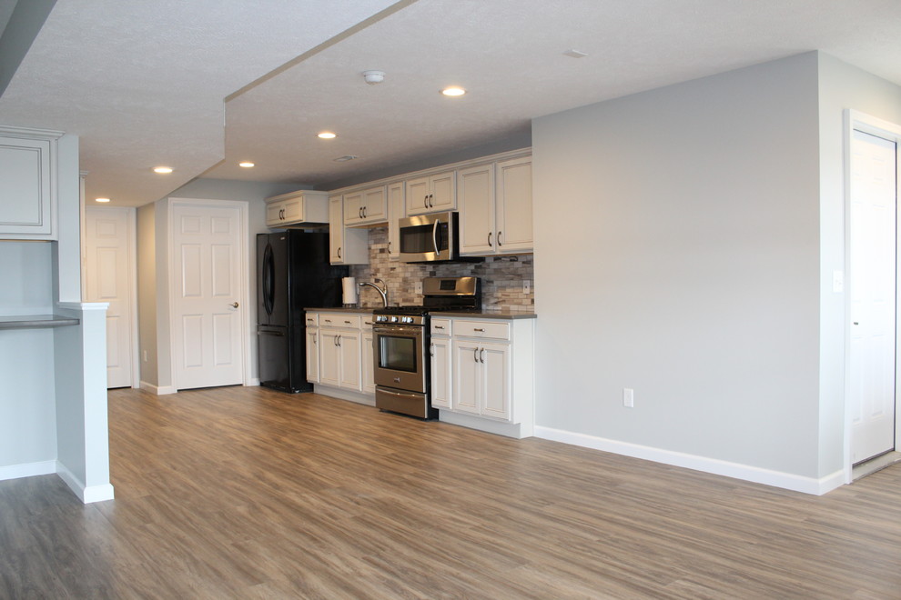 Basement - large modern walk-out laminate floor basement idea in Grand Rapids with gray walls