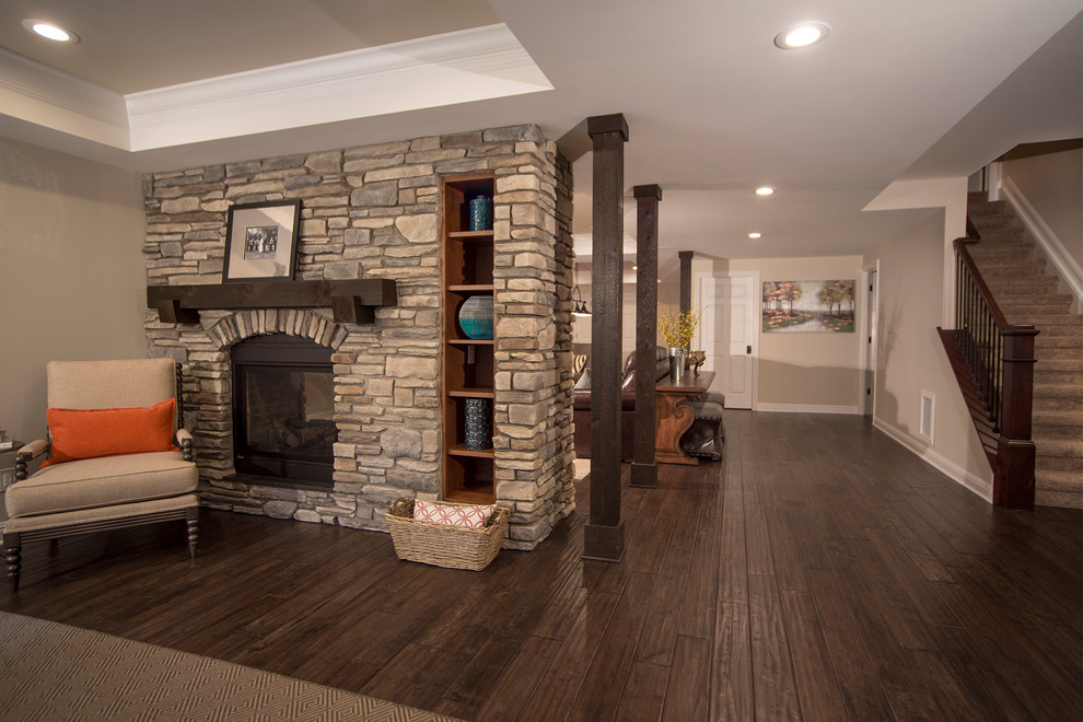 Basement - large rustic walk-out dark wood floor basement idea in Detroit with gray walls, a two-sided fireplace and a stone fireplace