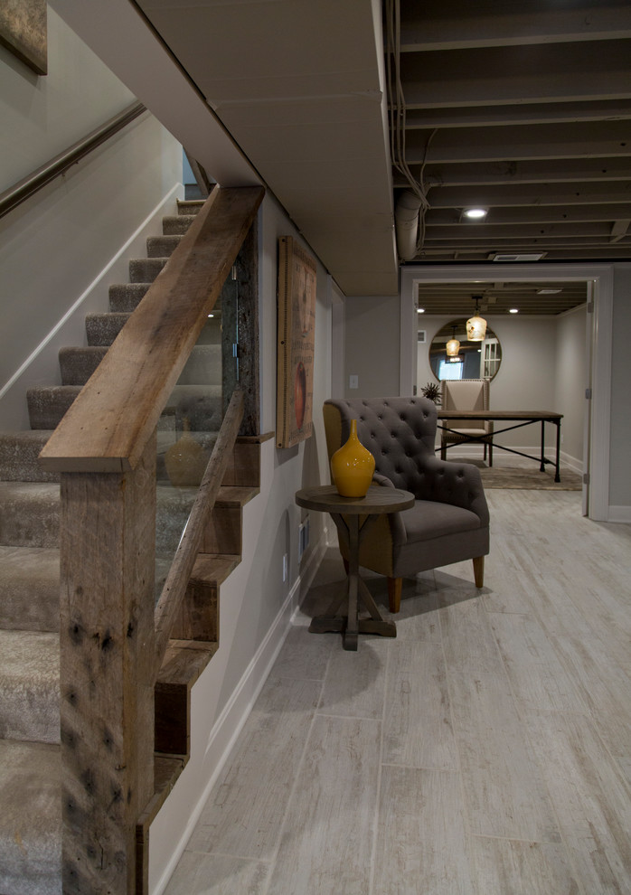 Großes Landhaus Untergeschoss mit grauer Wandfarbe, hellem Holzboden und grauem Boden in Kansas City