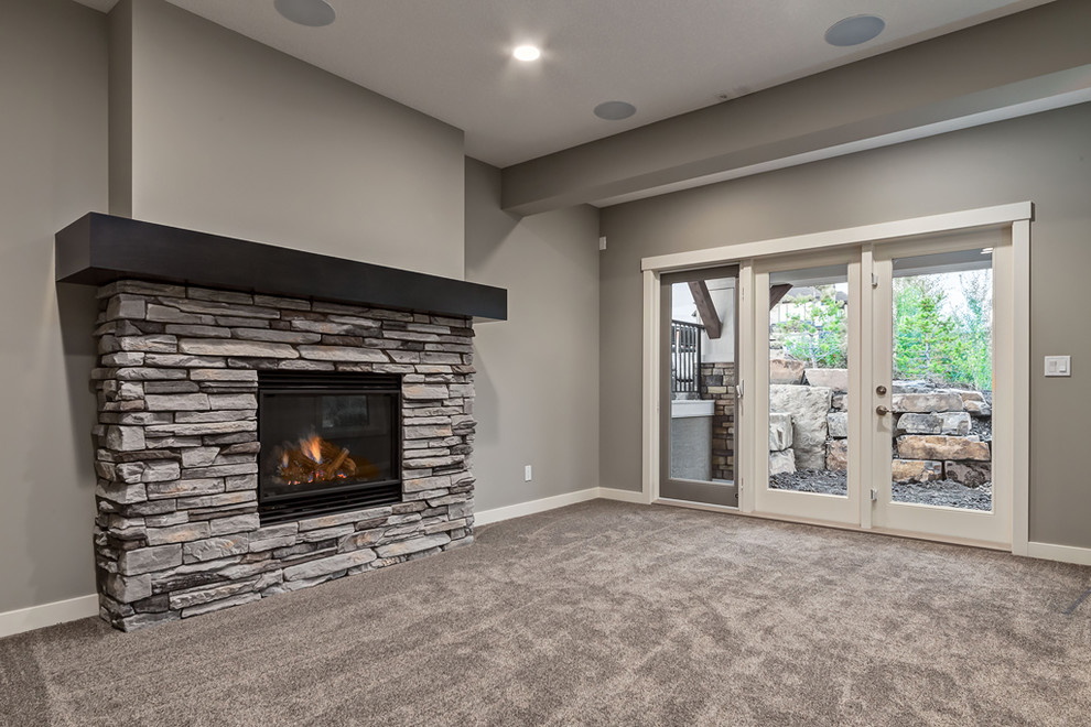 Inspiration for a traditional walk-out basement in Calgary with grey walls, carpet, a standard fireplace and a stone fireplace surround.