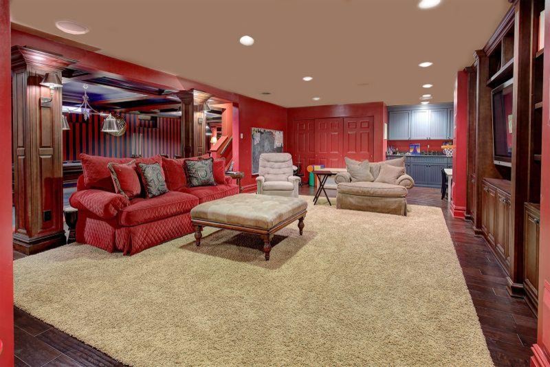 This is an example of a medium sized traditional fully buried basement in Las Vegas with red walls and dark hardwood flooring.