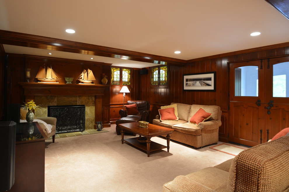 Example of a large classic walk-out carpeted and beige floor basement design in Milwaukee with a standard fireplace, a tile fireplace and brown walls