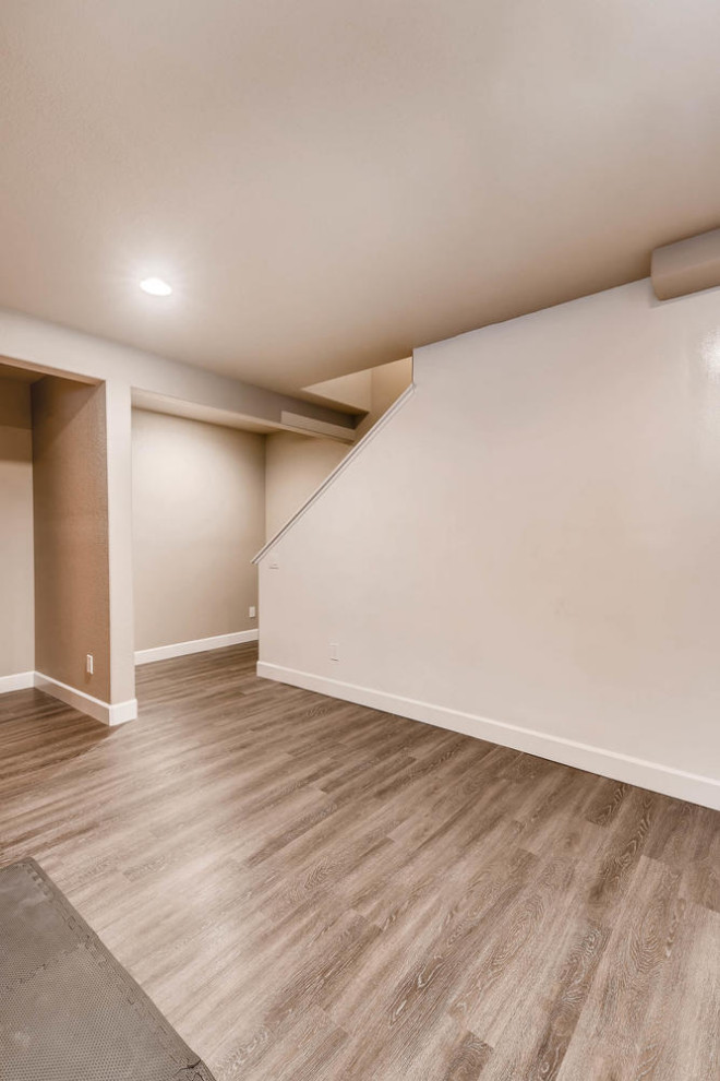 Design ideas for a medium sized classic look-out basement in Denver with beige walls and laminate floors.