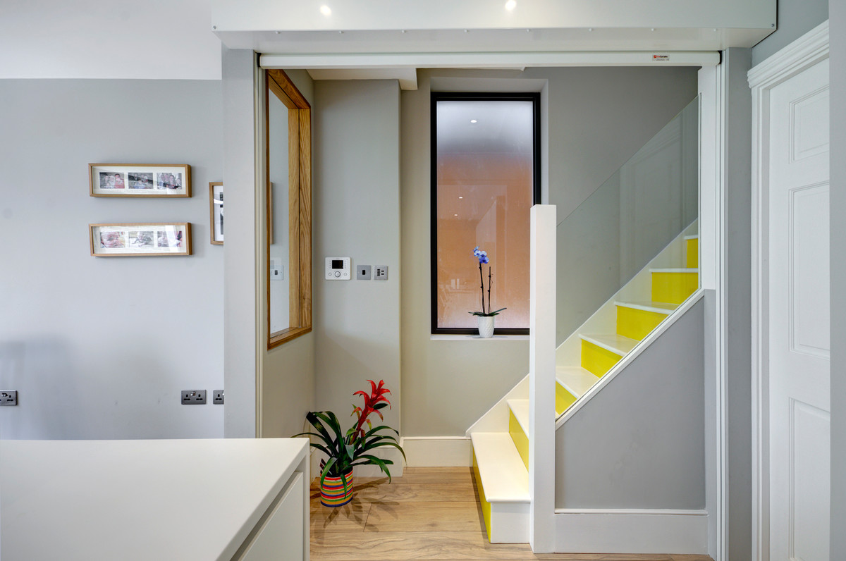 Источник вдохновения для домашнего уюта: большой подвал в современном стиле с выходом наружу, серыми стенами и паркетным полом среднего тона