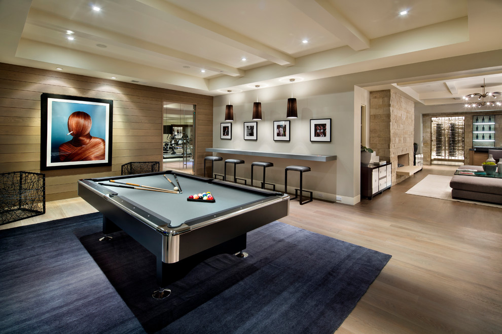 Photo of a contemporary fully buried basement in San Francisco with a standard fireplace, a stone fireplace surround, white walls, light hardwood flooring and beige floors.