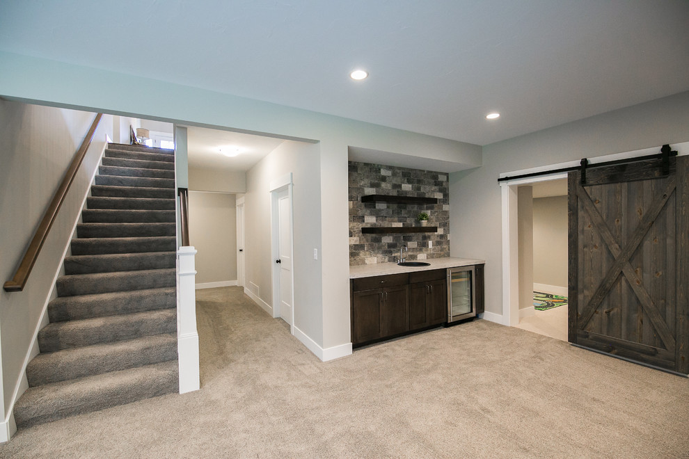 This is an example of a medium sized rural look-out basement in Grand Rapids with grey walls, carpet and grey floors.