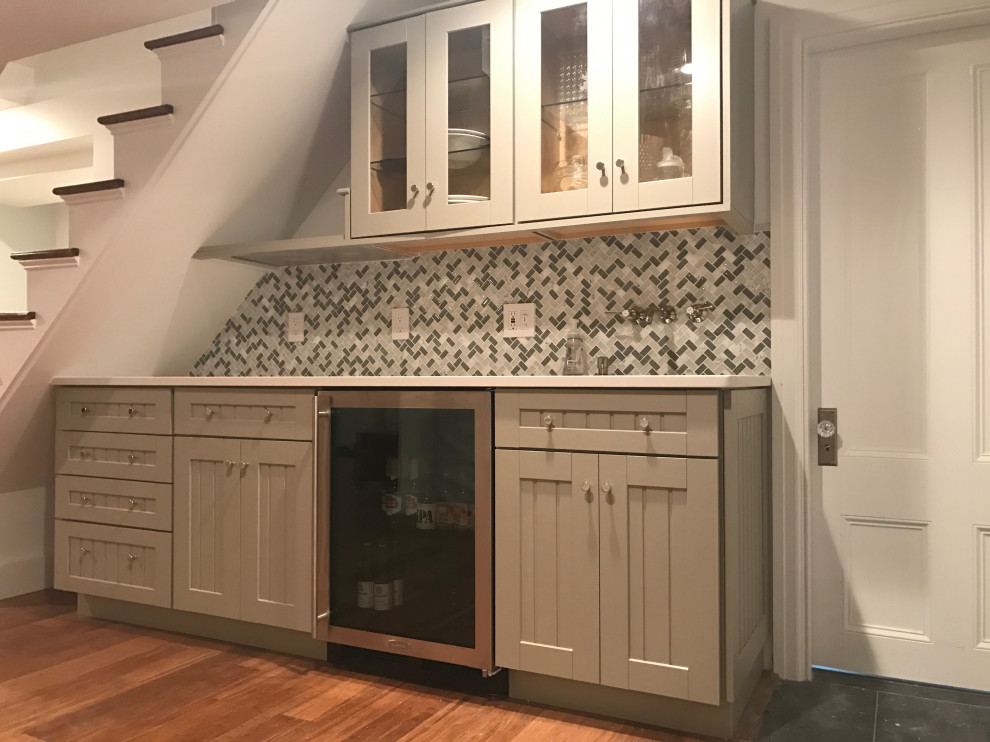 Medium sized contemporary fully buried basement in Boston with a home bar, bamboo flooring, a plastered fireplace surround and wainscoting.